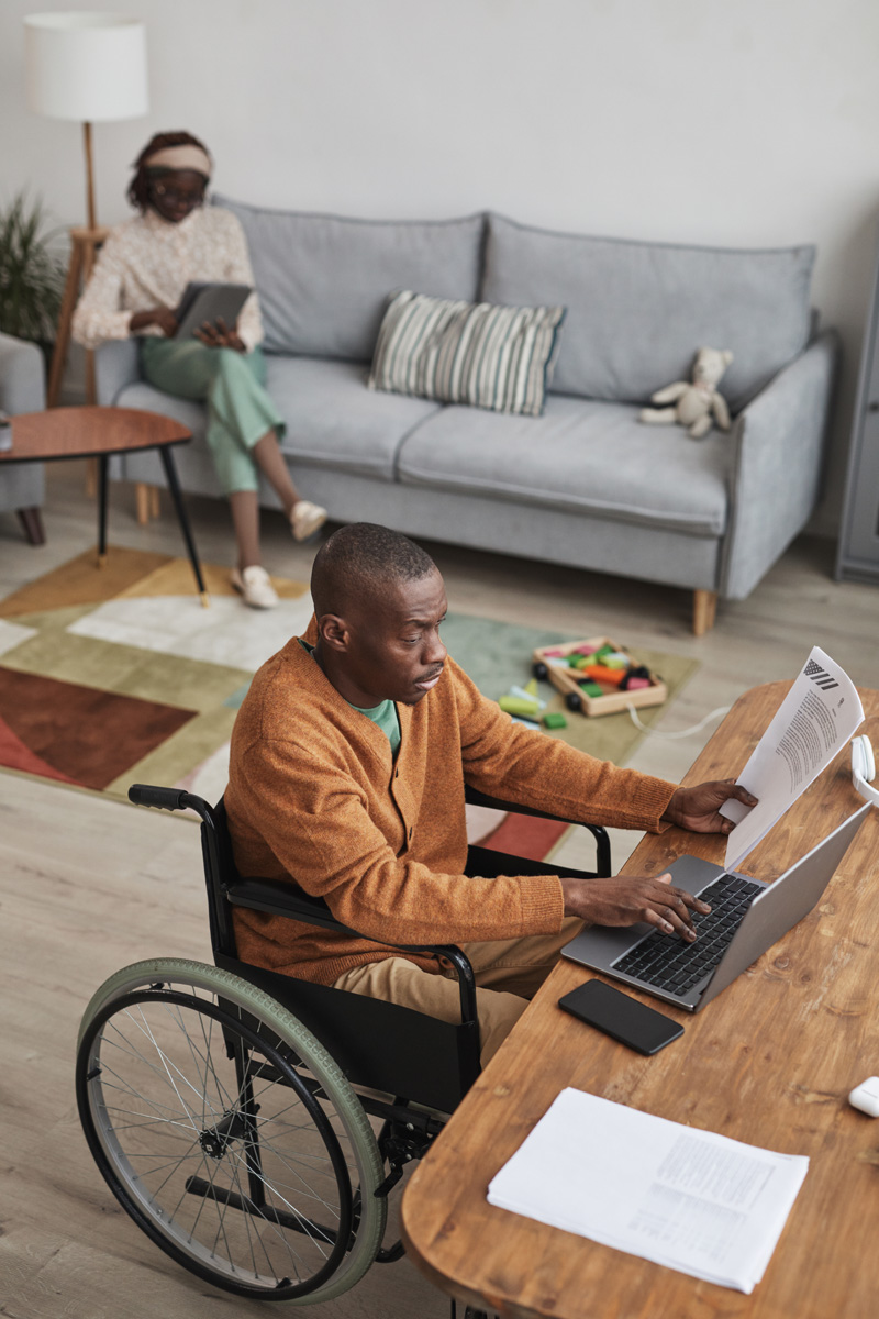 African American Man in Wheelchair Working from Home